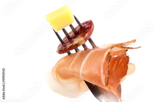 Fork food, food on the fork with salami, prosciutto and cheese isolated in white background.