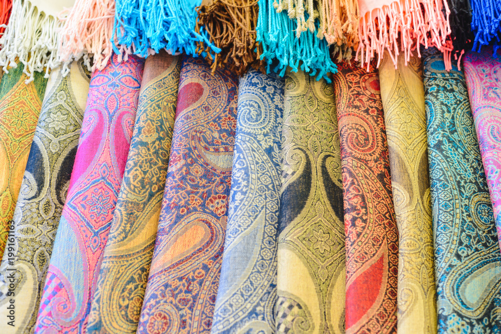 Many bright female scarfs and shawl close-up at shop Many bright female scarfs and shawl close-up at shop