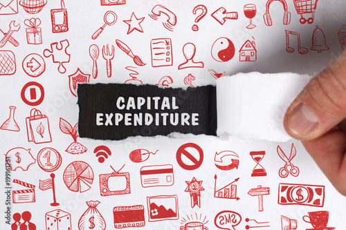 The concept of business, technology, the Internet and the network. Young businessman showing inscription: Capital expenditure