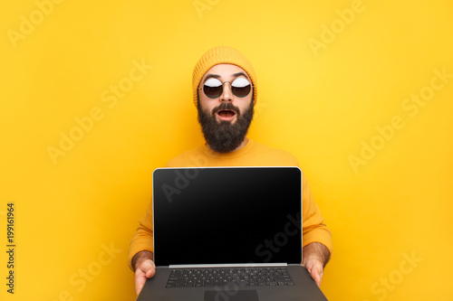 Trendy man advertising laptop 