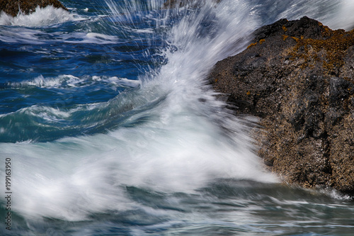 Sea water sprays a coastal rock in Oregon