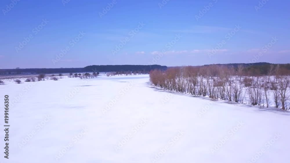 4K Aerial. Over winter frozen river with trees. White snow. 4K Aerial. Over winter frozen river with trees. White snow.