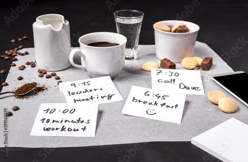 Time for breakfast in bussy day, table with coffee, chocolate and notes photo