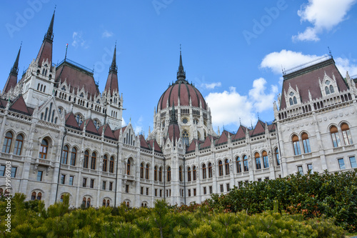 Budapest parliament with bushes in front with blue sky
