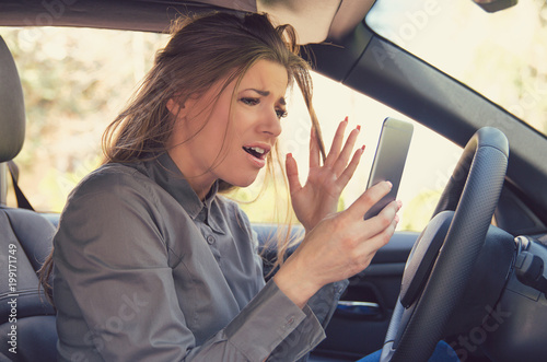 Scared woman with smartphone driving car © Feodora