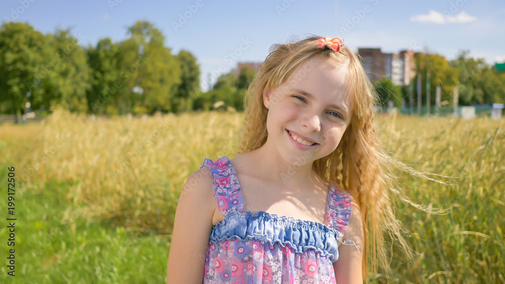 Portrait of a blonde and smiling Russian girl next to the field. Portrait of a blonde and smiling Russian girl next to the field.