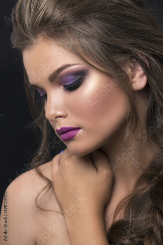 Beautiful girl with bright lilac makeup and braided hair looking down. Cover of fashion magazine.