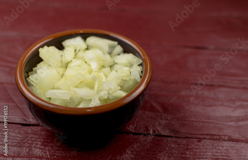 The chopped onion in a cup is filled with boiling water.
