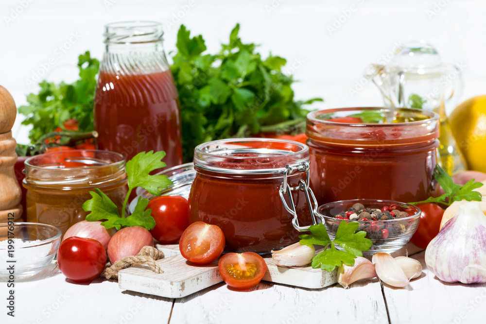 assortment of tomato sauces and ingredients on white wooden background assortment of tomato sauces and ingredients on white wooden background