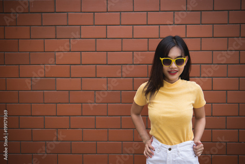 Portrait asian hipster girl on brick wall background,Thailand people wear yellow dress