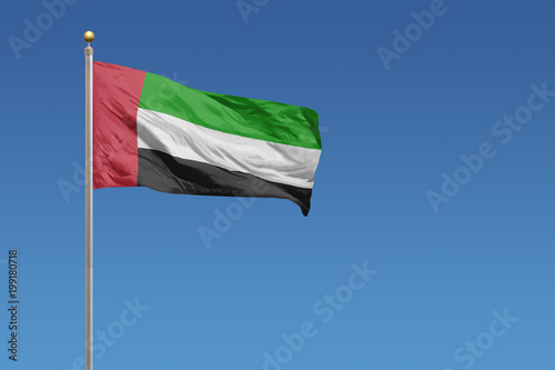 Flag of United Arab Emirates in front of a clear blue sky