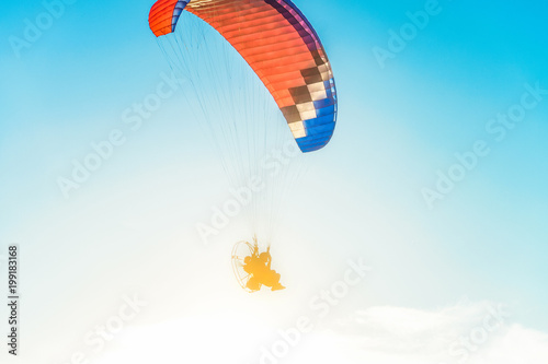 Flight on a motor glider in the blue sky with bright backlight sunlight. Solar illumination of the pilot. photo