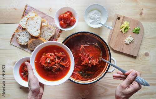 Ukrainian traditional borsch. Russian vegetarian red soup in white bowl on wooden background. Top view. 
