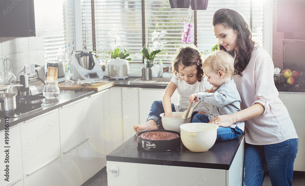 Pretty mother making cake with her beloved children Pretty mother making cake with her beloved children