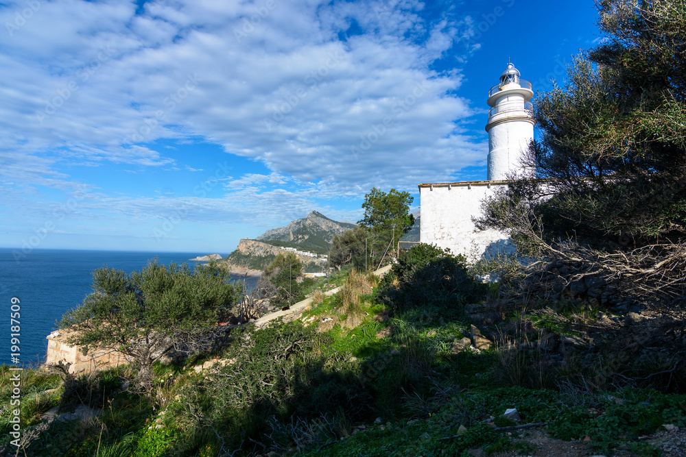 White lighthouse in northwest Mallorca between mountains. Mediterranean Sea. Seascape