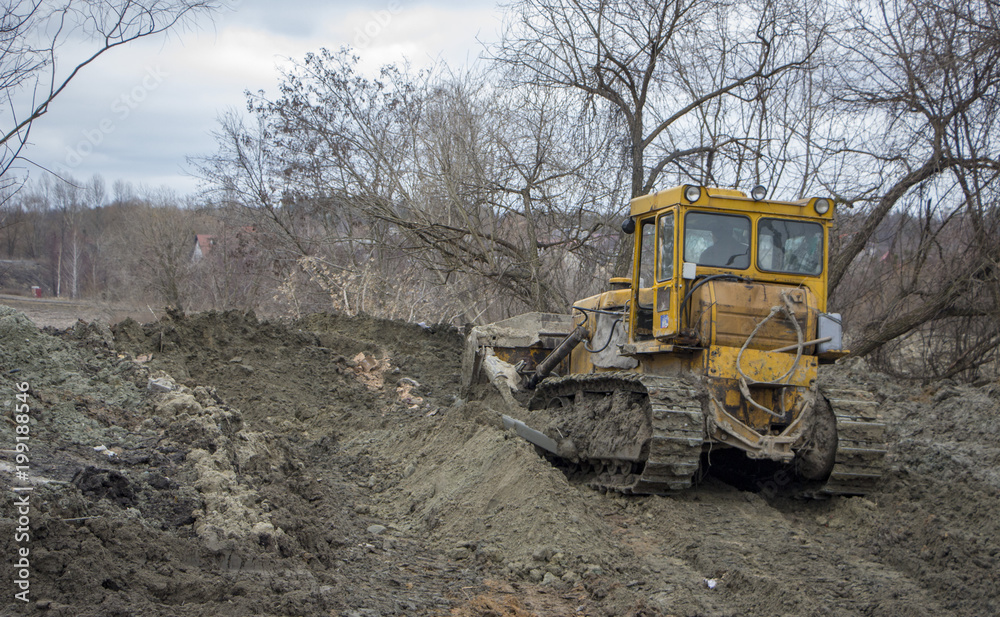 A large bulldozer digs a reclamation channel