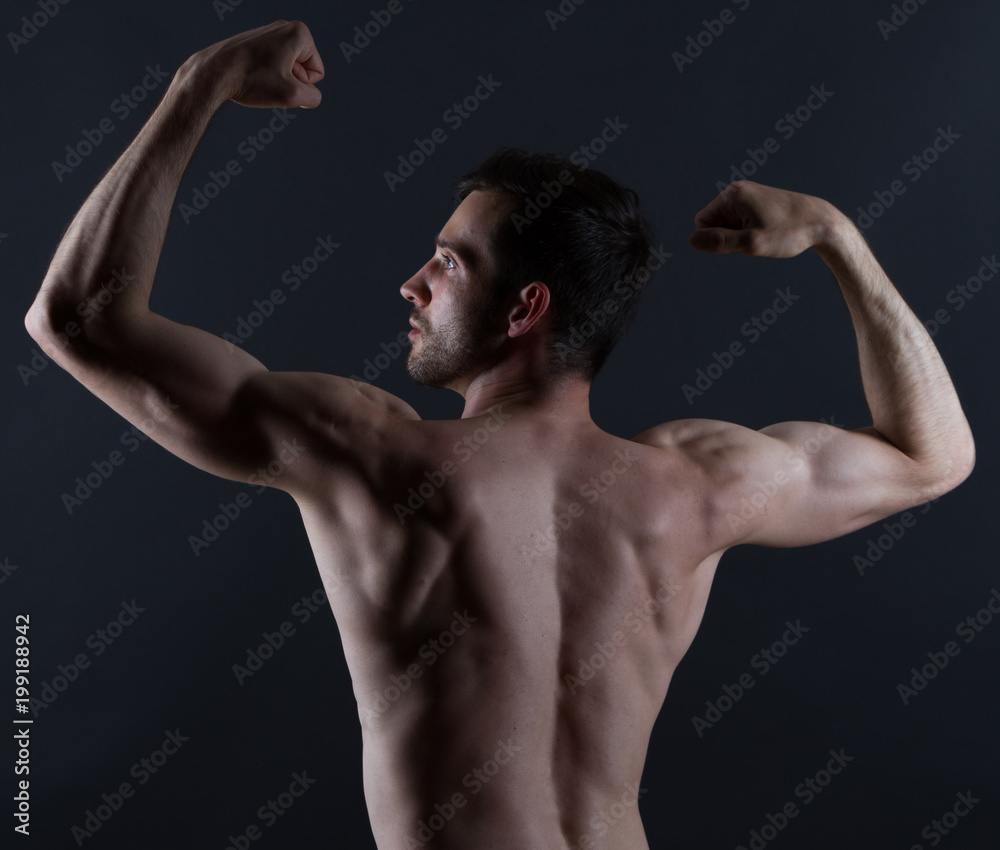 young mans back with muscles on black background young mans back with muscles on black background