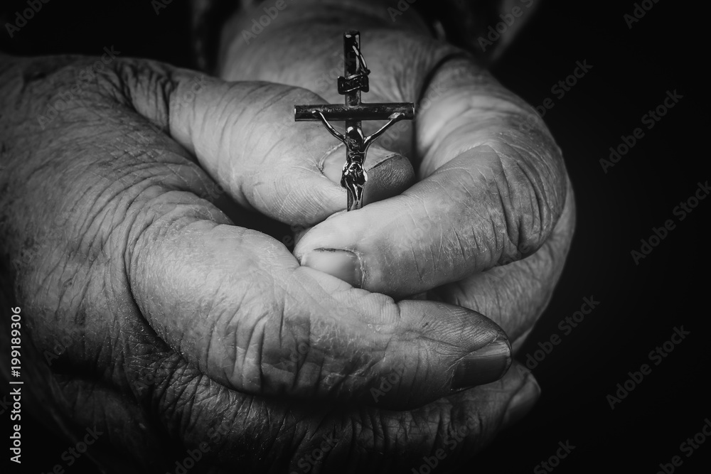 Obraz premium he cross is in the hands of the old man.