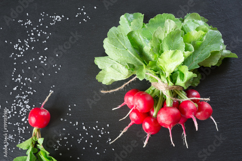 Fresh radish on black slate background. View from above.