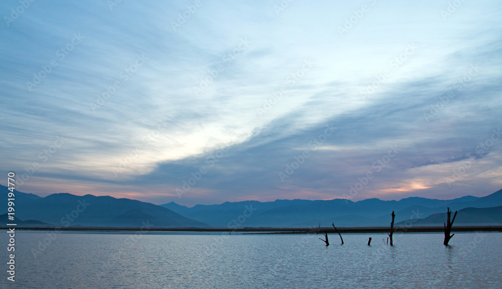 Lake Isabella sunrise with partially submerged tree trunks in Central California United States Lake Isabella sunrise with partially submerged tree trunks in Central California United States