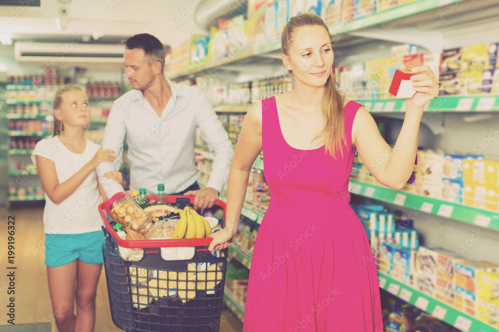 family of three choosing food in the grocery shop