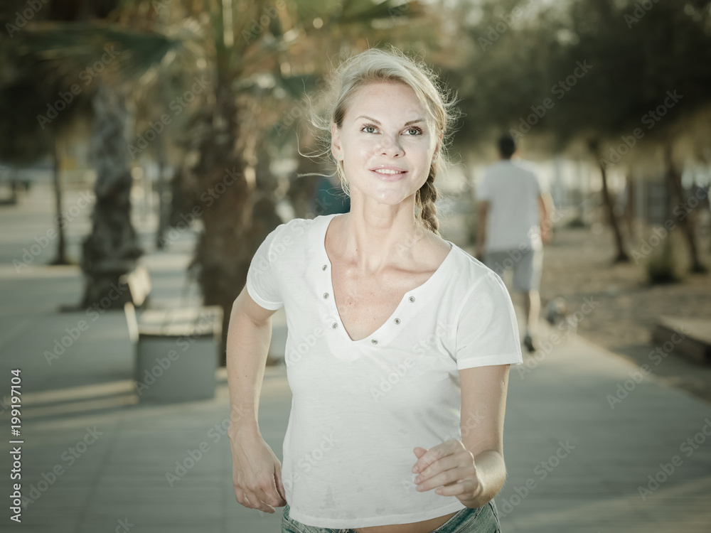 Female in white T-shirt is jogging