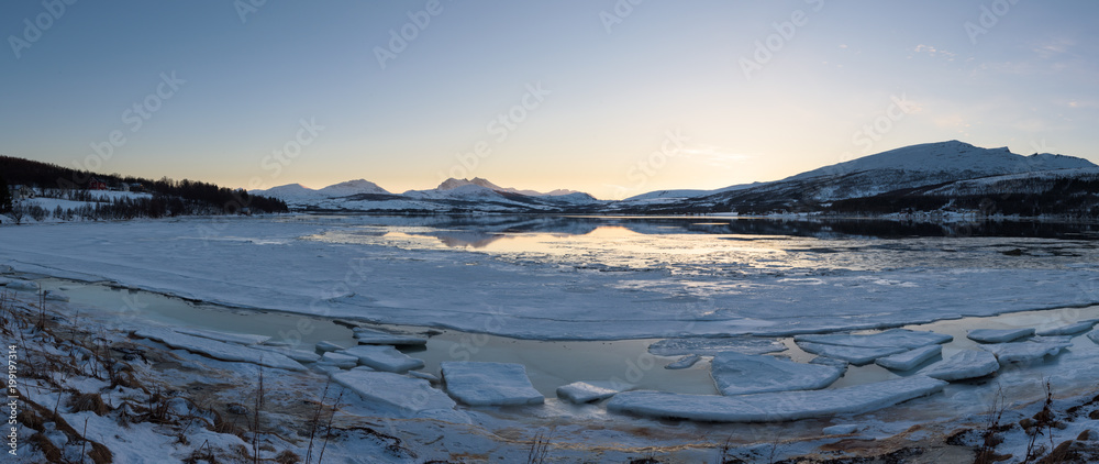 A Norwegian fjord near Tromsø covered with ice at sunset, Tromsø, Norway A Norwegian fjord near Tromsø covered with ice at sunset, Tromsø, Norway