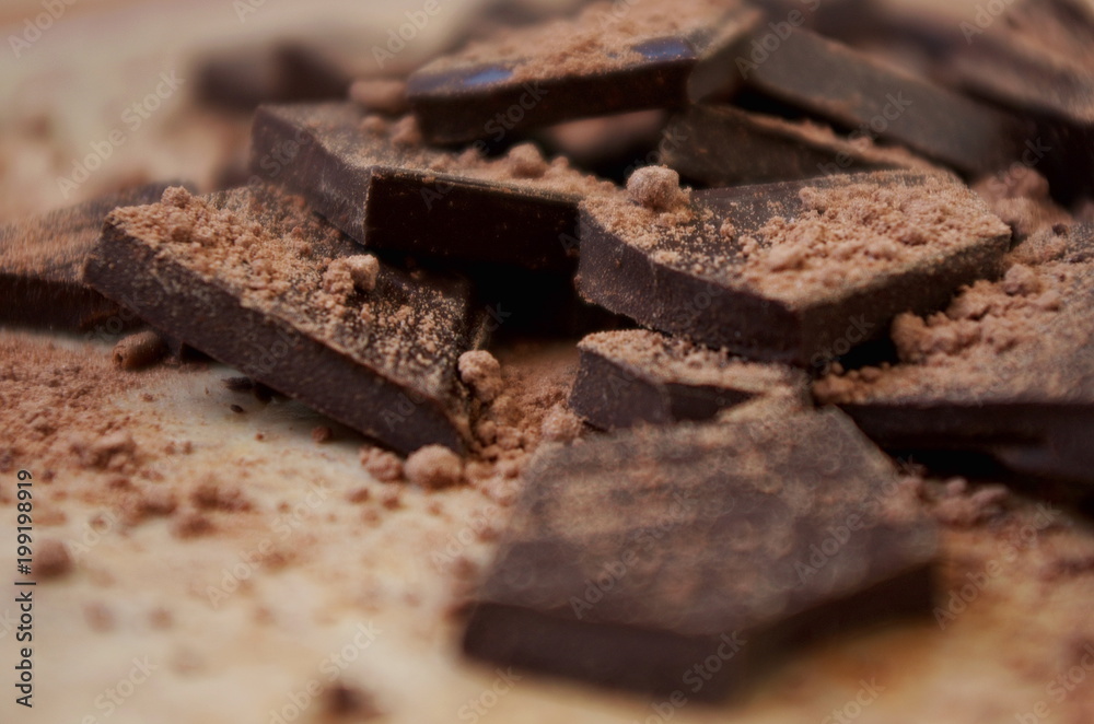 Cocoa powder and Chocolate bar close up. Pile of broken dark chocolate and cocoa powder. Cocoa powder and Chocolate bar close up. Pile of broken dark chocolate and cocoa powder.