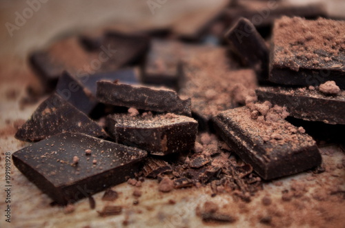 Cocoa powder and Chocolate bar close up. Pile of broken dark chocolate and cocoa powder.