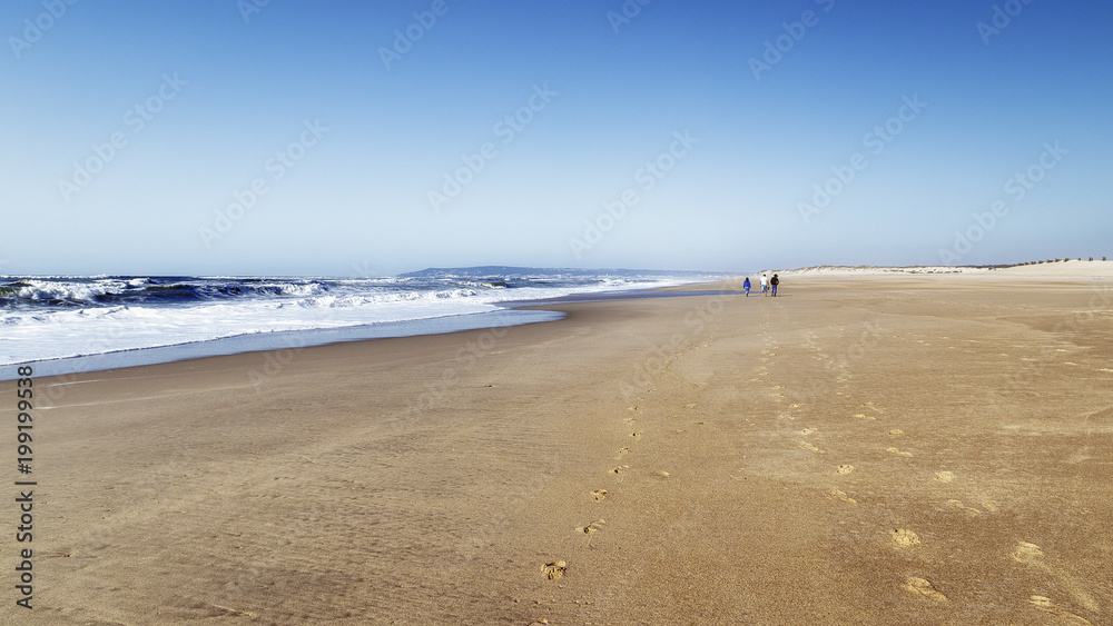 Tres personas caminando por la playa