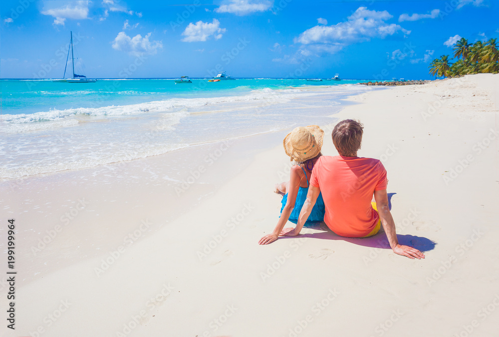 back view of couple sitting on a tropical beach in Barbados back view of couple sitting on a tropical beach in Barbados