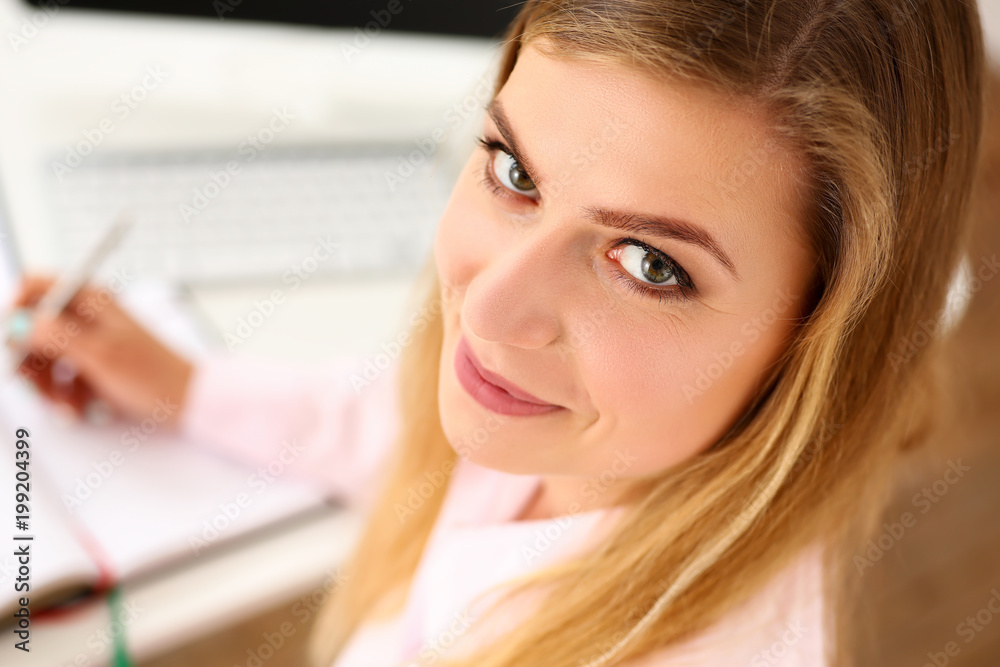 Beautiful smiling girl at workplace hold silver pen Beautiful smiling girl at workplace hold silver pen