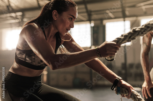 Obraz na plátně Woman doing strength training with battle ropes