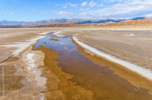 Salt Creek - Springtime new salt creek emerging on salt flats at mountain base. Death Valley National Park, California, USA.