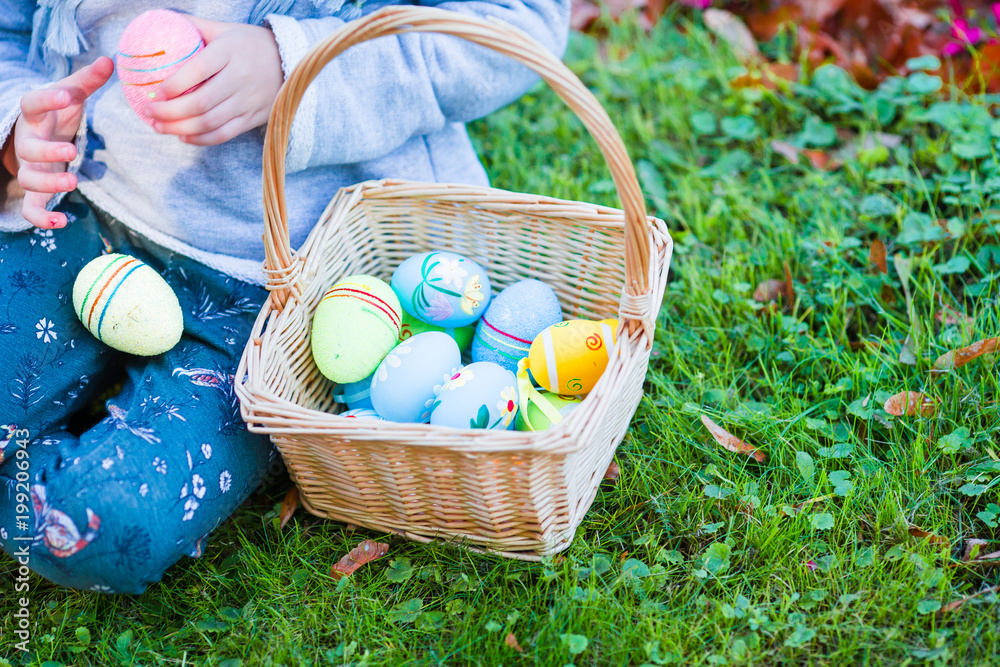 Closeup basket full of colorful Easter eggs in kids hands Closeup basket full of colorful Easter eggs in kids hands