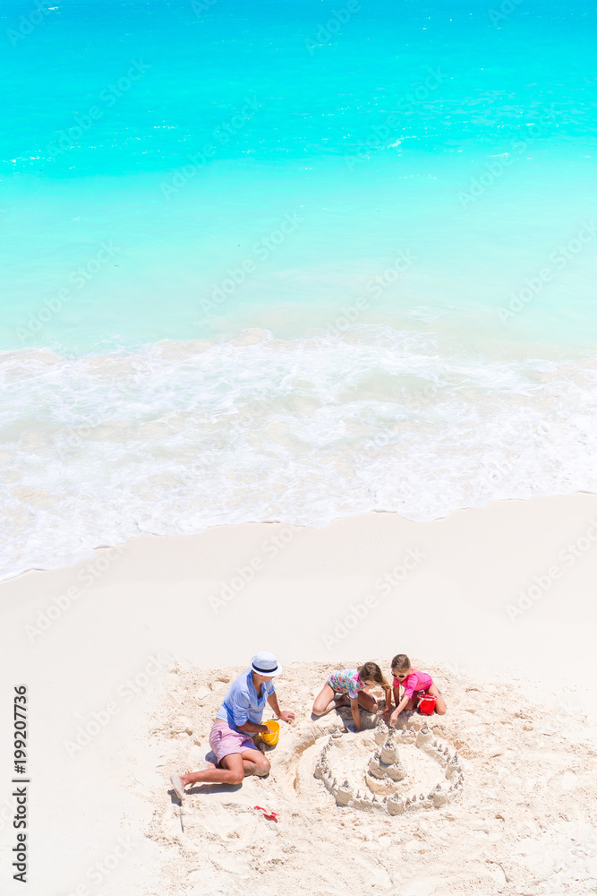 Family making sand castle at tropical white beach view from above Family making sand castle at tropical white beach view from above