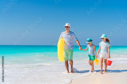 Father and little kids enjoying beach summer tropical vacation. Family playing on the beach
