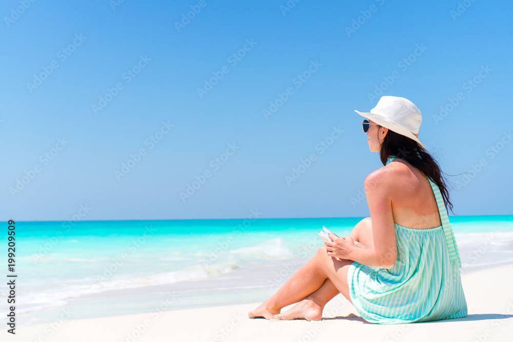 Woman sitting on beach enjoying summer holidays Woman sitting on beach enjoying summer holidays