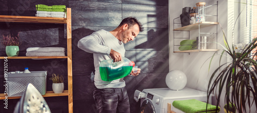 Man pouring liquid laundry detergent In the bottle cap photo