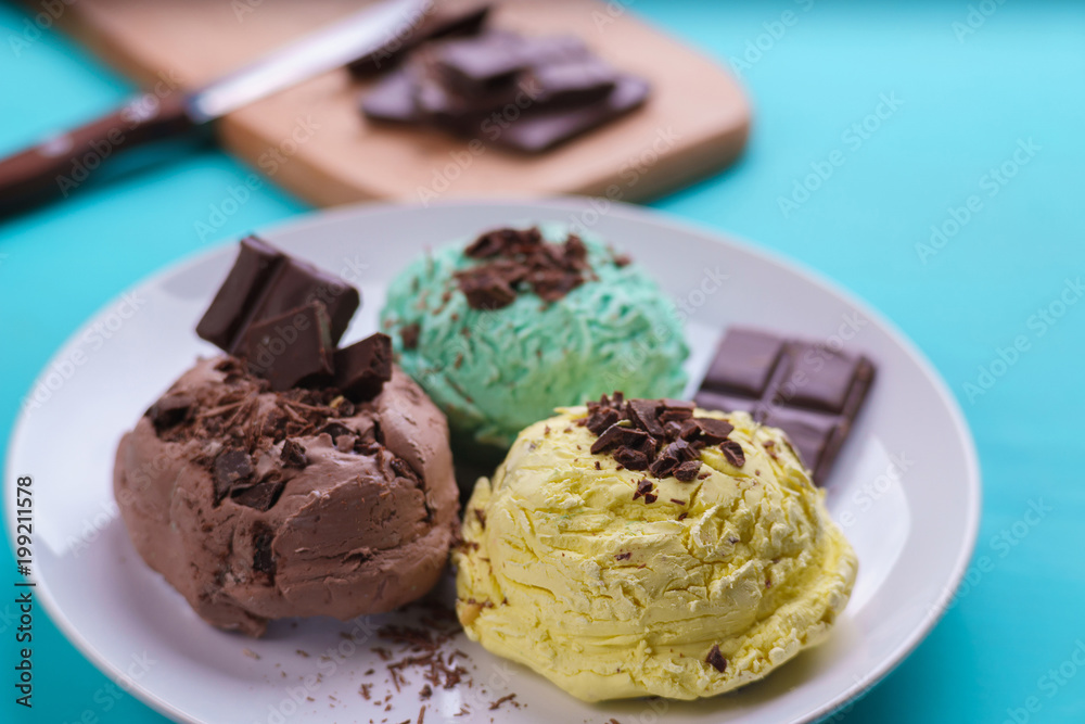 Mint, banana and chocolate ice cream scoops with chocolate crumbs served on white plate. Delicious refreshing summer sweets, close up Mint, banana and chocolate ice cream scoops with chocolate crumbs served on white plate. Delicious refreshing summer sweets, close up