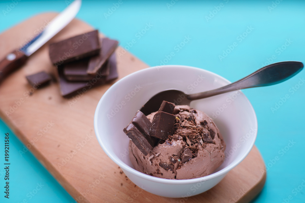 Chocolate ice cream in bowl and broken chocolate bar on serving board. Delicious summer treat close up Chocolate ice cream in bowl and broken chocolate bar on serving board. Delicious summer treat close up