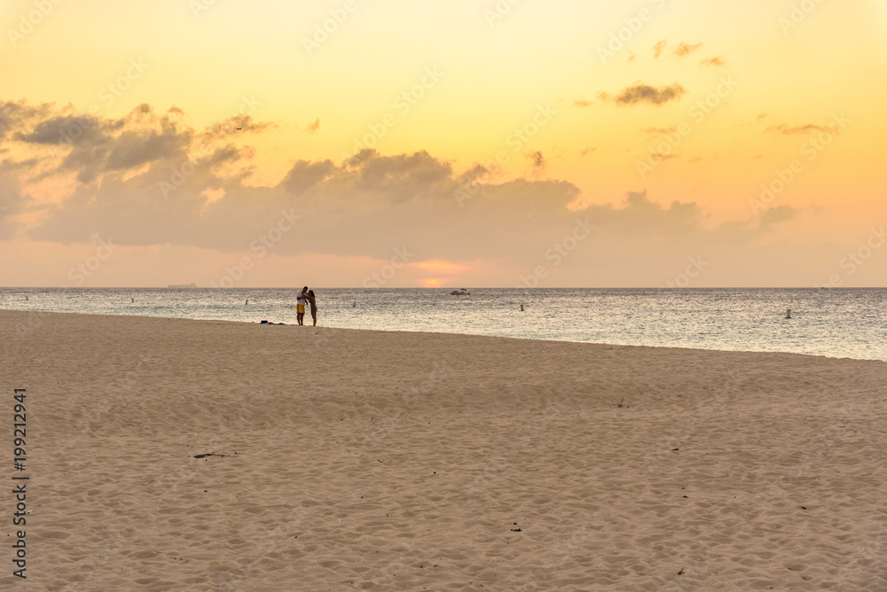 Caribbean beach at sunset with a couple