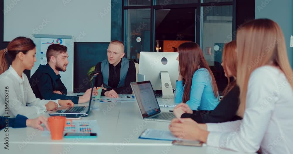 Handsome young director talks with colleagues in the conference room Handsome young director talks with colleagues in the conference room