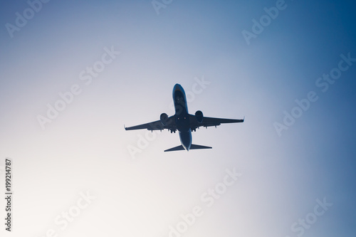 flying airplane silhouette in blue sky dusk