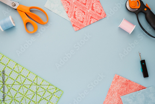Quilting tools and fabric on a light blue background