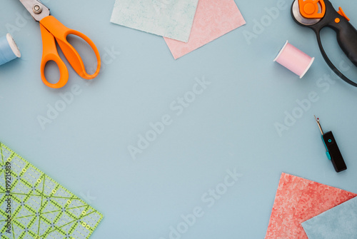 Quilting tools and fabric on a light blue background