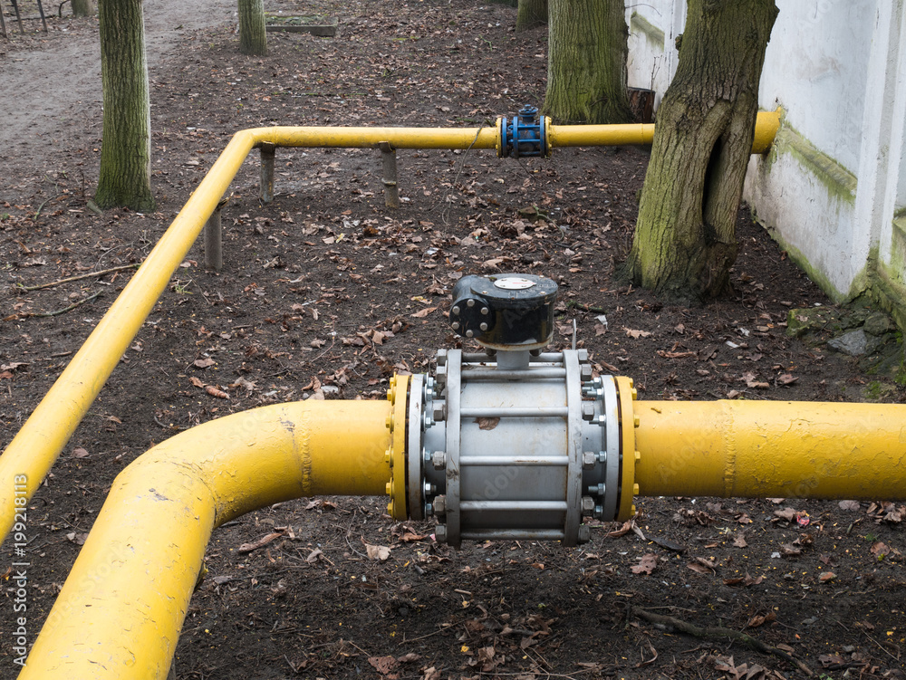 big valve on a thick yellow gas water pipeline tube big valve on a thick yellow gas water pipeline tube