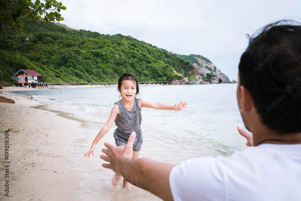 Little girl and happy dad having fun during beach vacation.