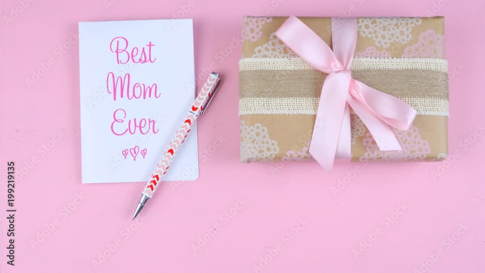 Time lapse of Happy Mother's Day overhead with roses, Best Mom Ever card and gift on pink wood table. Time lapse of Happy Mother's Day overhead with roses, Best Mom Ever card and gift on pink wood table.