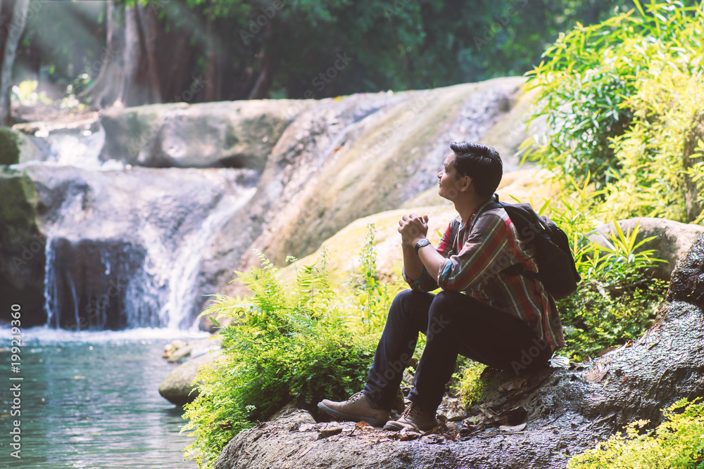 Traveler man with backpack holding camera with green natural background. Traveler man with backpack holding camera with green natural background.